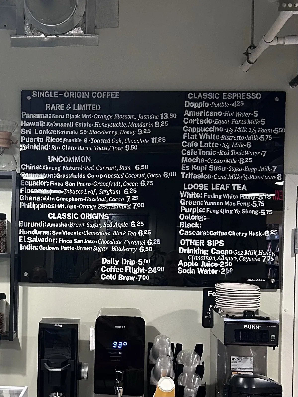 The menu board, divided into three single-origin categories, classic espresso drinks and loose-leaf teas.